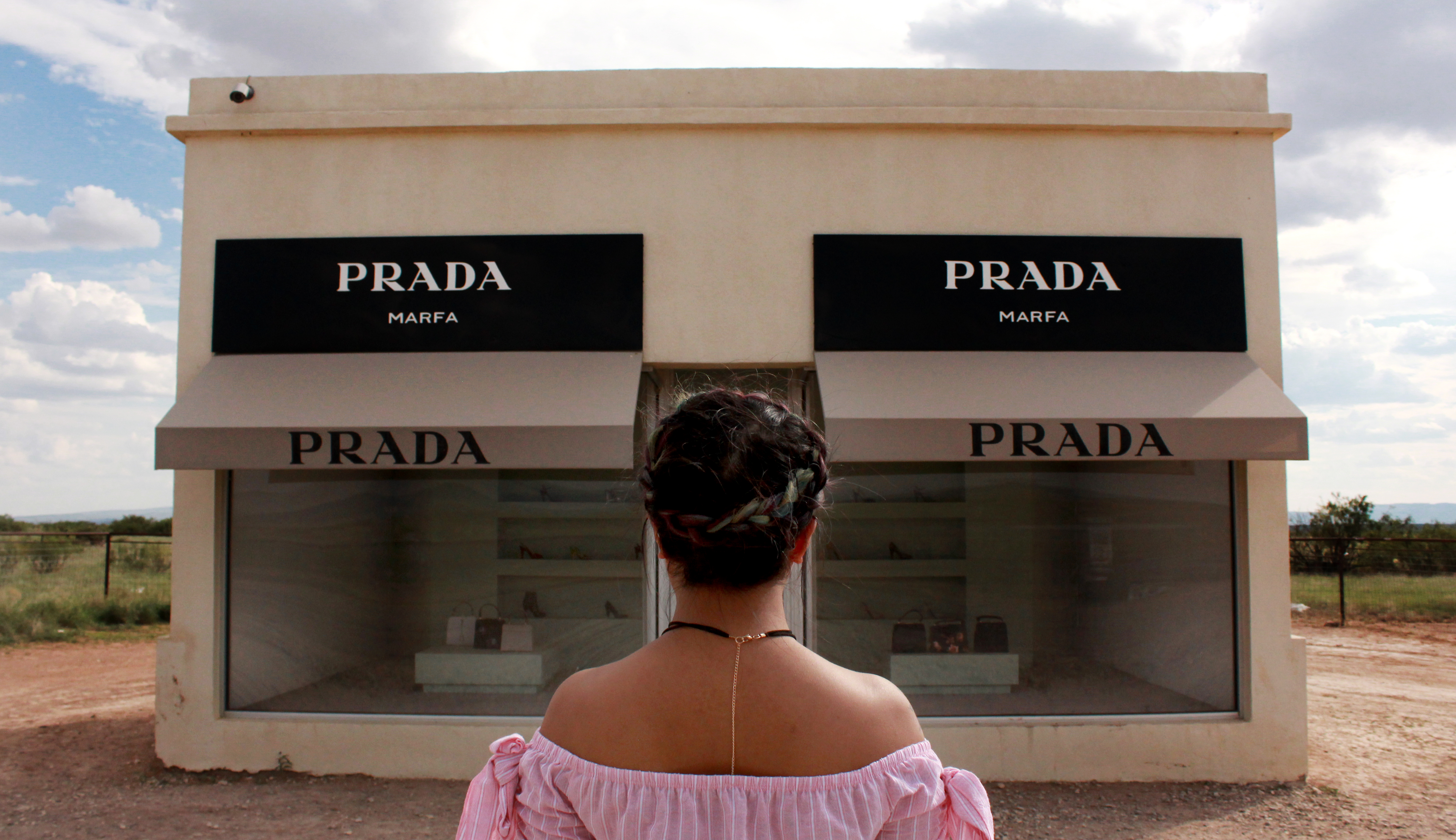 girl facing vacant prada store front